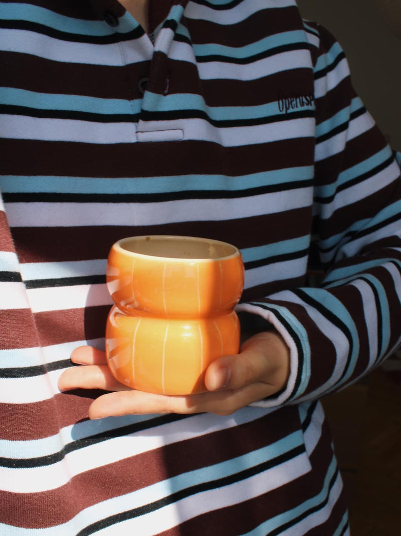 Hand holding Tangerine ceramic cup with orange gradient glaze, handmade mug for coffee and tea